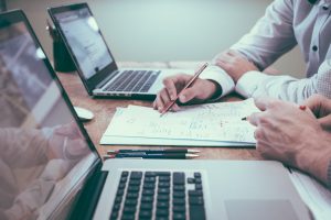 executivos escrevendo notebooks