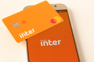Cartão do Banco Inter e um celular com o logo da instituição