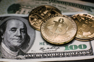 Moedas de Bitcoin sob cédulas de US$ 100