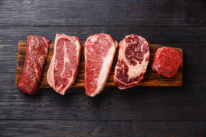 cortes de carne bovina crua sobre uma mesa escura