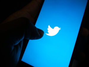 pessoa segura celular com logotipo do Twitter exibido na tela