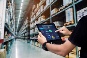 Estoque de empresa com um funcionário organizando via tablet