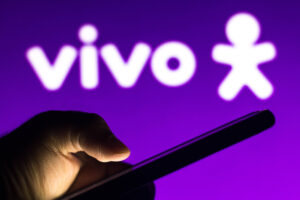 Celular com logo da vivo ao fundo