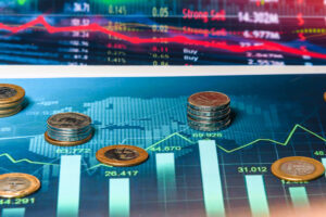 Imagem de moedas de reais sobre gráfico de mercado