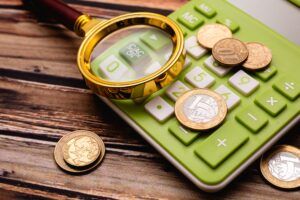 calculadora e uma lupa para enxergar a moeda