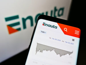 Celular com logo da Enauta e computador atrás com mesma imagem