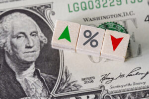 dados com setas para cima e para baixo e símbolo de porcentual sobre uma nota de dólar