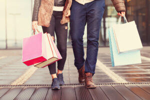 casal caminha com sacolas de compras