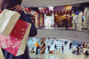 mulher segura sacolas de compras em shopping center