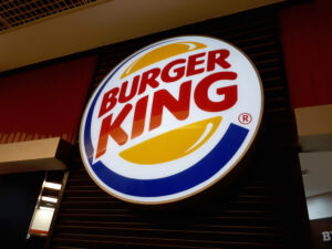 Letreiro da rede de fast food Burger King (BK), com a logo da marca contendo cores vermelha, amarela e azul.