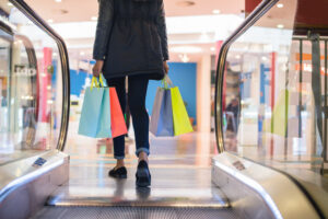 Mulher caminhando com sacolas em shopping center