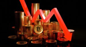 Moedas de Bitcoin com seta apontando para baixo