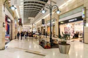Corredor de shopping com pessoas ao fundo Aliansce Sonae brMalls