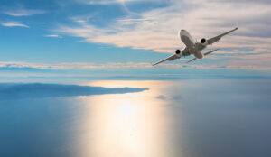 Avião manobrando com o mar ao fundo
