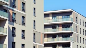 Fachada de duas torres de prédios residenciais com sacadas em tons crus.