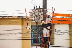 Técnico em escada para instalação de energia elétrica