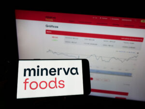 Celular com logo da Minerva e site da mesma no fundo