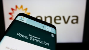 Smartphone em frente ao logotipo da Eneva em uma tela de computador