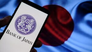 Celular com o logotipo do Banco do Japão e bandeira do Japão ao fundo